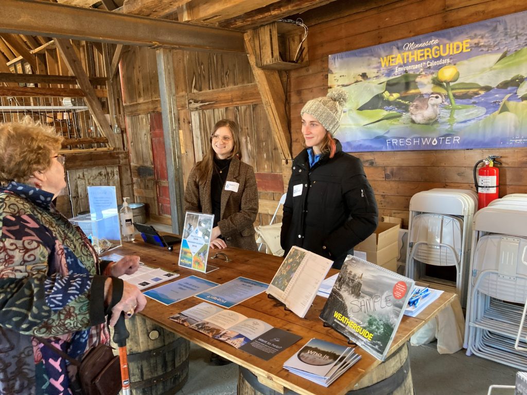 Freshwater staff Chyann (left) and Olivia (right) chat with an orchard visitor.